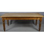 A Victorian style pine refectory farmhouse kitchen table on turned tapering supports. H.76.5 L.199