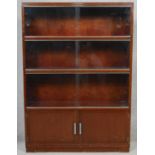 A mid century vintage Minty bookcase with sliding glass doors above panel doors with maker's label