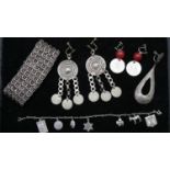 A collection of silver jewellery. Including an Israeli silver charm bracelet, silver coin earrings a