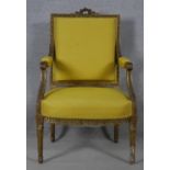 A 19th century Louis XVI style giltwood fauteuil with carved back rail and arms raised on tapering