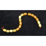 A string of seventeen antique amber prayer beads. (one cracked) L.24cm