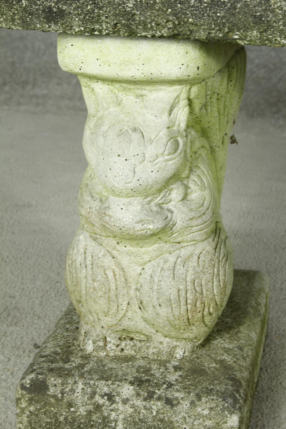 A weathered reconstituted stone garden bench on twin supports. H.46 W.128 D.38cm - Image 3 of 7