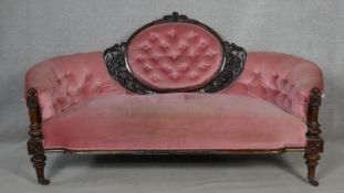 A Victorian carved walnut framed sofa in deep buttoned velour upholstery on fluted tapering