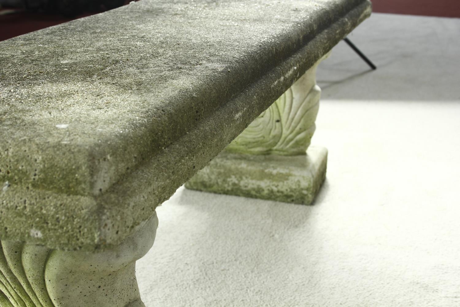 A weathered reconstituted stone garden bench on twin supports. H.46 W.128 D.38cm - Image 7 of 7