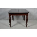 A William IV style mahogany extending dining table with two extra leaves on reeded tapering supports