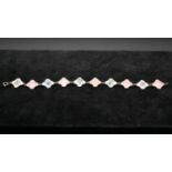 A Danish silver and guilloche enamel link bracelet. Alternating links in pink and white with various