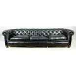 A three seater Chesterfield sofa in deep buttoned leather upholstery on bun feet. H.70 W.275 D.90cm