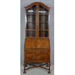 A mid century burr walnut William and Mary style bureau bookcase with glazed upper section above