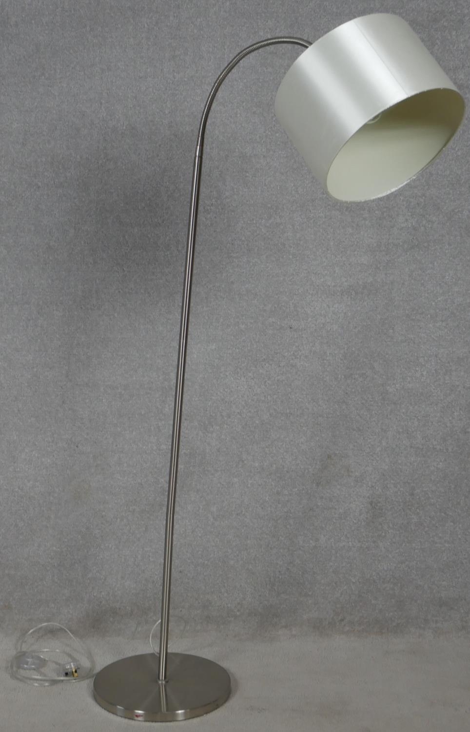 A contemporary standard lamp and shade with flexible adjustable column for use as a reading lamp.