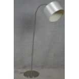 A contemporary standard lamp and shade with flexible adjustable column for use as a reading lamp.