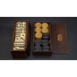 A 19th century boxed set of bone and ebony dominos with a set of boxwood draughts in a wooden box