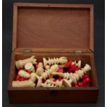 A 19th century complete carved ivory chess set, one set stained red, with engraved detaling in a