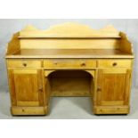 A 19th century pitch pine desk with shaped galleried back above inset leather top over pedestal