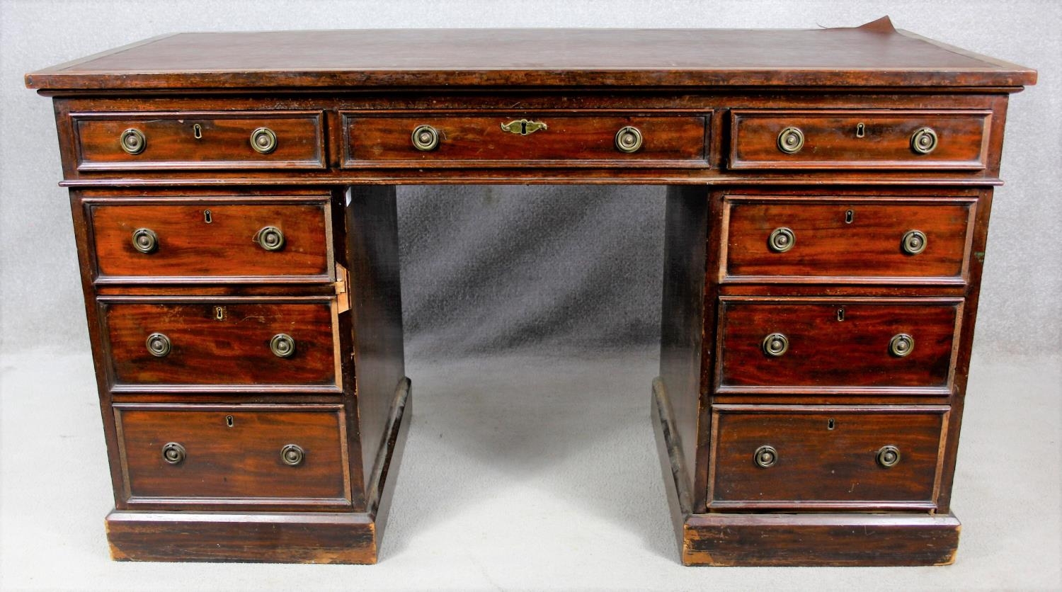 A 19th century three part mahogany pedestal desk with an arrangement of nine drawers on plinth base.