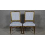 A pair of 19th century Louis XVI style carved giltwood dining chairs in striped upholstery on fluted