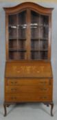 An Edwardian mahogany bureau bookcase with satinwood swag and urn inlay to the fall front raised