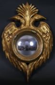 A carved giltwood convex mirror with double eagle head cresting to the frame. H.34 W.22cm