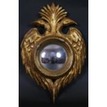 A carved giltwood convex mirror with double eagle head cresting to the frame. H.34 W.22cm