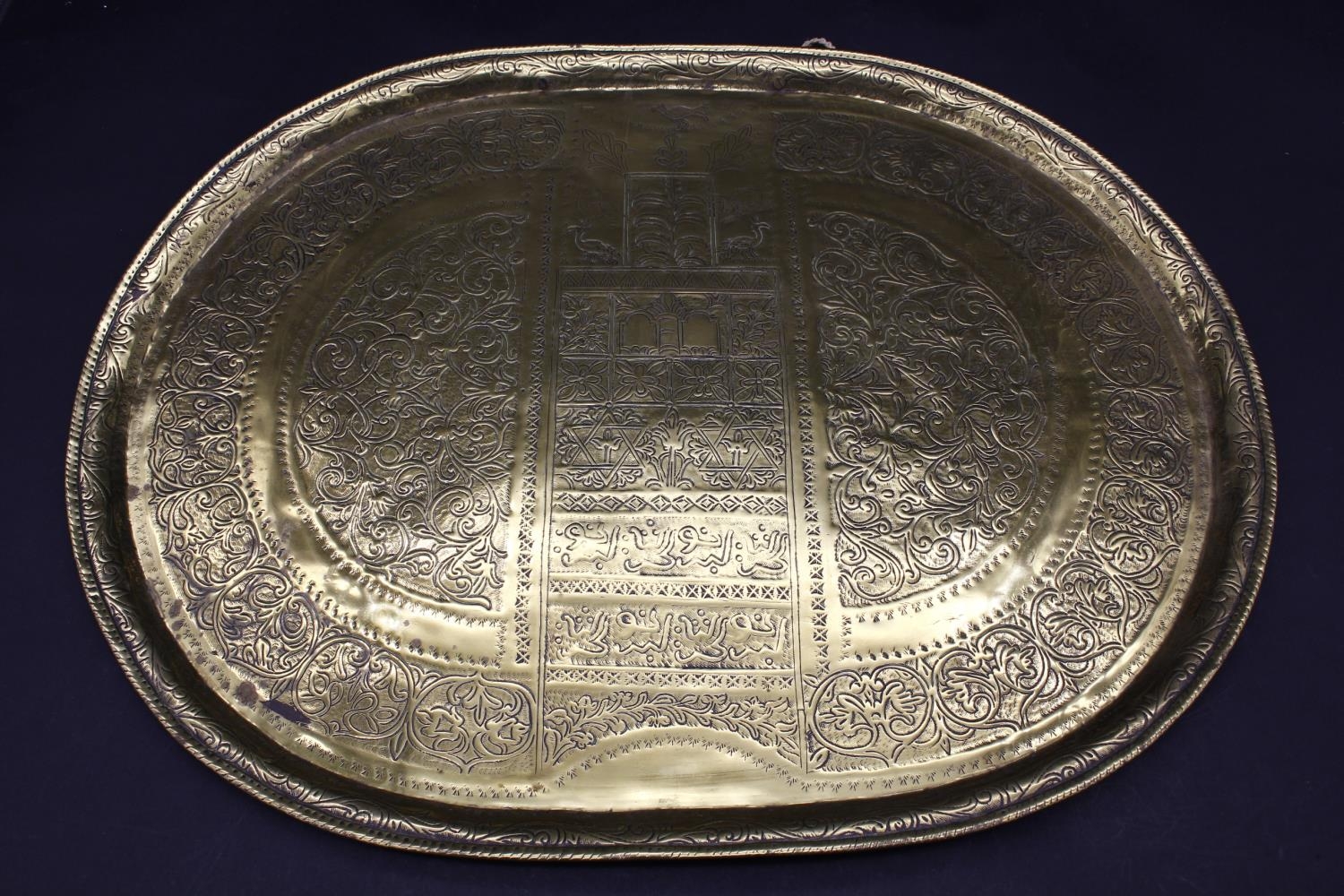 A brass serving platter embossed with the Star of David and Hebrew writings with all over