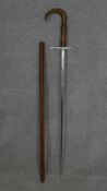 A C.1900 Toledo sword stick, with engraved steel blade and tusk handle with brass banding. L.91cm