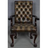 A mid Georgian style mahogany library armchair in deep buttoned and studded leather upholstery