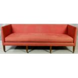 A Georgian style sofa upholstered in calico raised on eight square tapering supports terminating