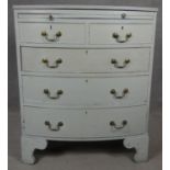 A Georgian style white painted bowfronted chest of drawers with brushing slide and brass swan neck