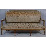 A carved and giltwood Louis XVI style canape in cut floral upholstery raised on fluted turned