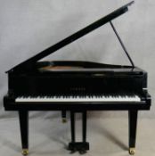 A Yamaha G1 grand piano in black gloss lacquered case on brass roller castors, serial number 2083203