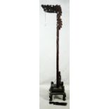 A Chinese style hardwood standard lamp carved in the form of a dragon. H.183cm