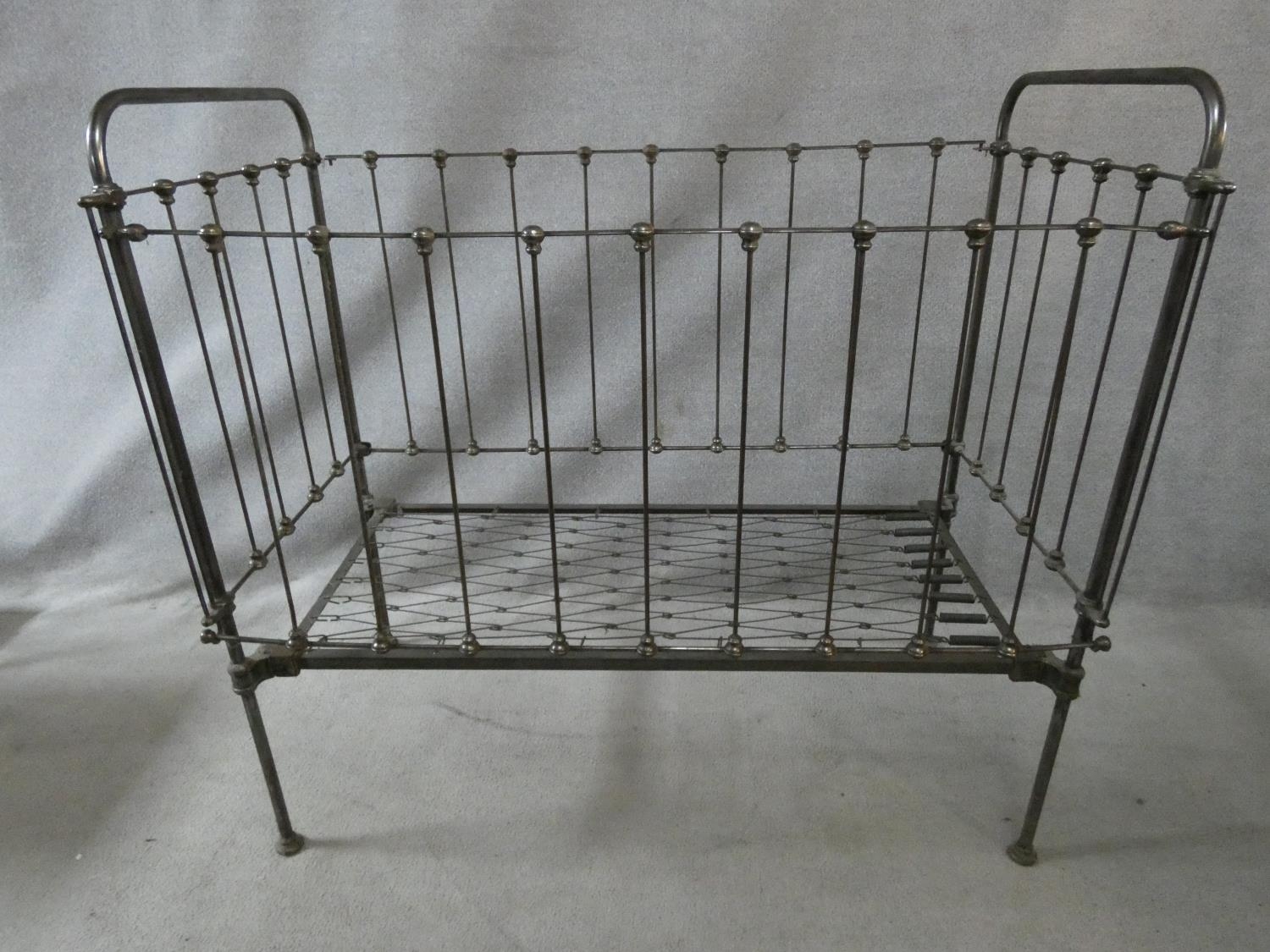 A Victorian wrought iron child's cot with fall front panel. H.114 L.124 W.63cm