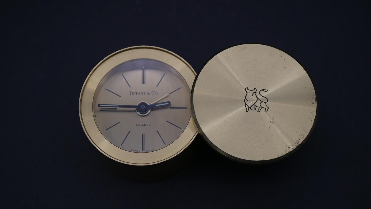 A Tiffany & Co. miniature portable alarm clock with Merrill Lynch logo to the sliding case cover,