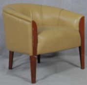 A contemporary tub shaped armchair in piped leather upholstery on tapering supports. H.74 W.75 D.