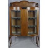 An Edwardian mahogany display cabinet with floral satinwood inlay and coloured leaded glass doors on