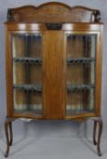 An Edwardian mahogany display cabinet with floral satinwood inlay and coloured leaded glass doors on