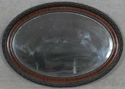 An early 20th century oval wall mirror with bevelled plate. H.61.5 W.86cm