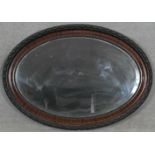 An early 20th century oval wall mirror with bevelled plate. H.61.5 W.86cm