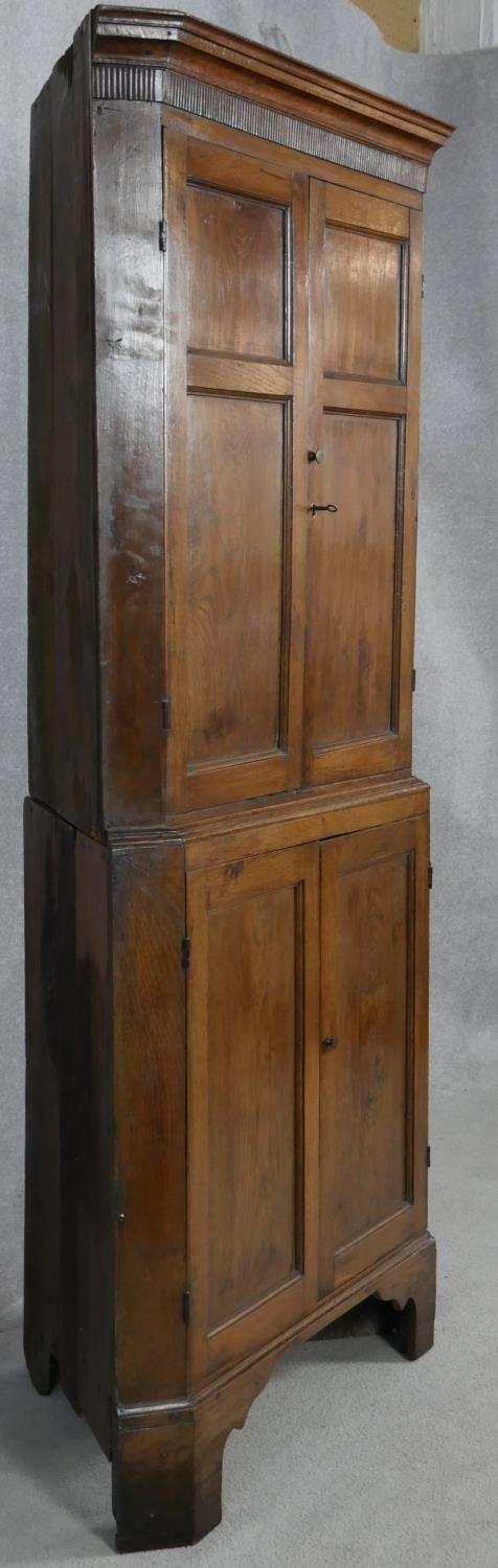 A Georgian oak two section corner cupboard with panel doors enclosing shelves on shaped bracket - Image 4 of 4