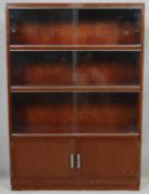 A mid century vintage Minty bookcase with sliding glass doors above panel doors with maker's label