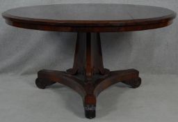 A Regency rosewood tilt top dining table on acanthus scroll carved pedestal and platform base. H.