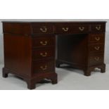 A Georgian style mahogany three section pedestal desk with an arrangement of nine drawers on bracket