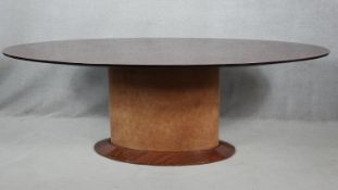 A contemporary oval dining table on maple pedestal base. H.76 L.220 W.120cm