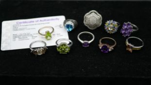 Ten gemset rings, one with certificate. To include a 9ct yellow gold peridot ring, amethyst ring,