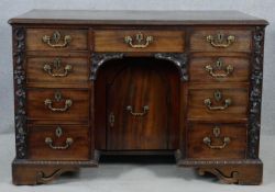 A Georgian mahogany Chippendale style desk fitted with kneehole cupboard and an arrangement of