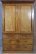 A mid 19th century mahogany linen press with stepped cornice over panel doors enclosing slides above