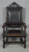 A late 19th century oak throne armchair in the Carolean style with carved cresting and arms in