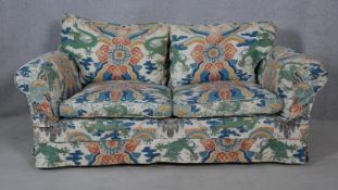 A two seater sofa in polychrome Chinese design upholstery. H.75 W.160 D.100cm