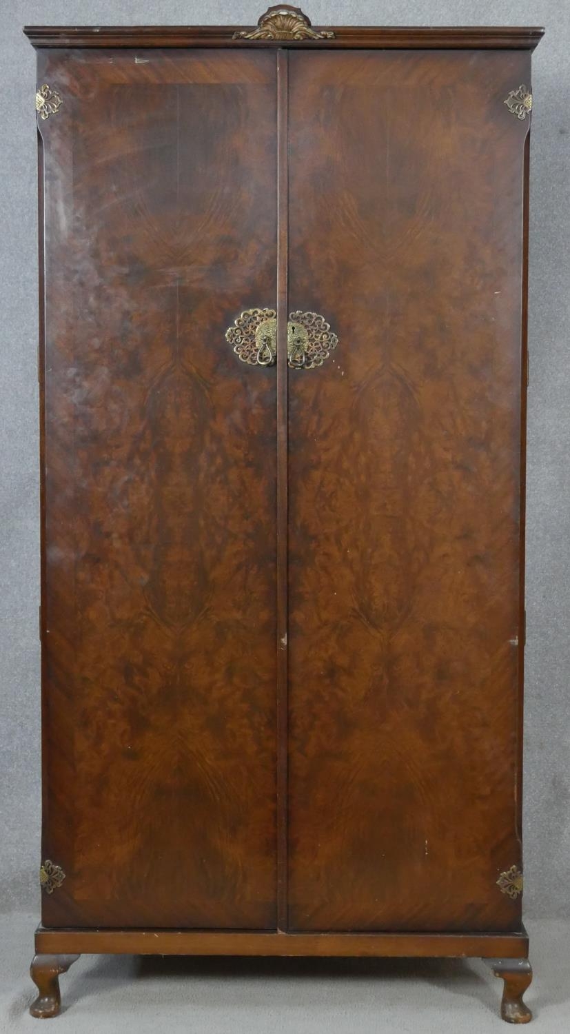 A mid century burr walnut gentleman's wardrobe fitted with interior glazed cabinet and labelled