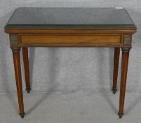 A late 19th century French Empire style mahogany and brass inlaid card table with fold over top