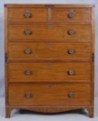 A Regency mahogany chest of drawers with satinwood and ebony inlay and shaped apron on swept bracket